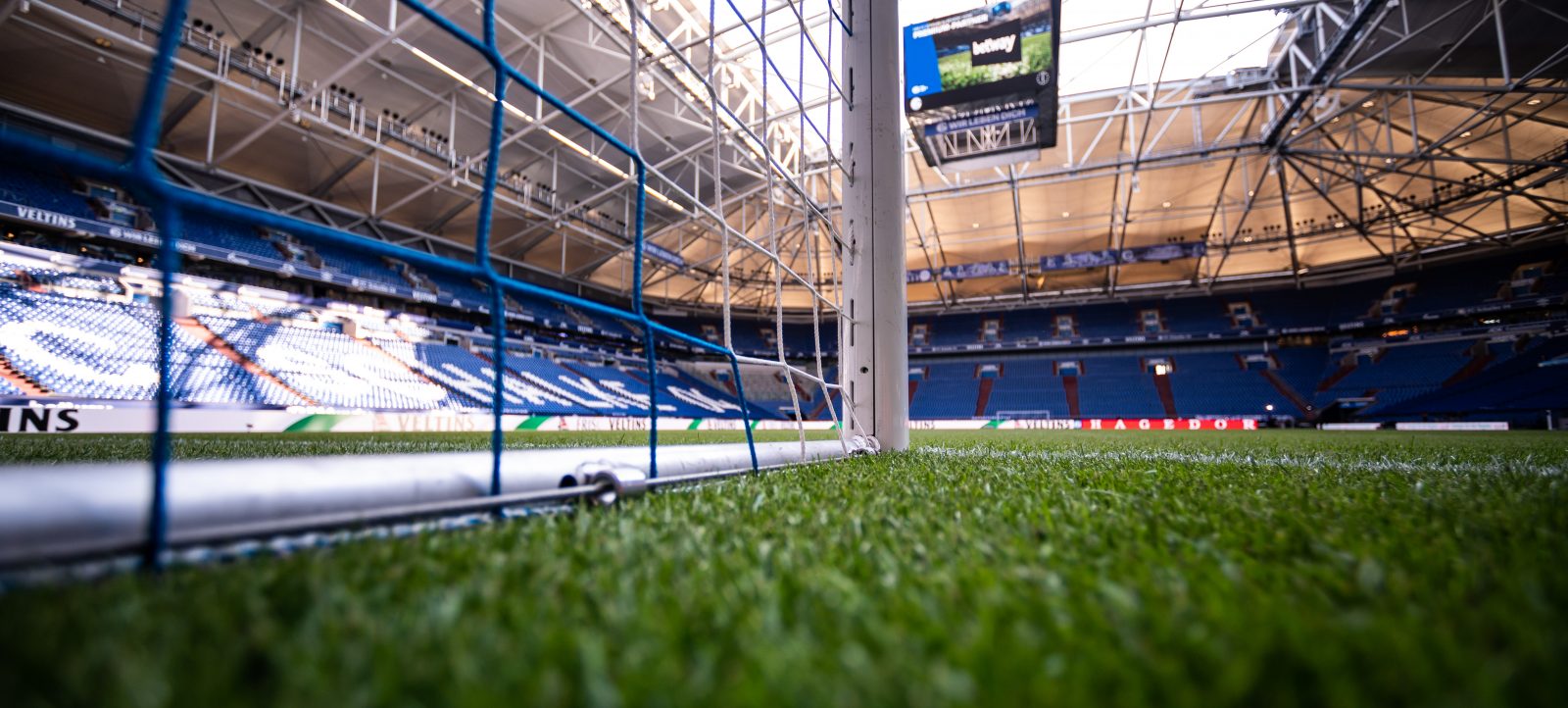 Allgemeiner Blick ins Stadion vor dem Zweitliga-Spiel zwischen FC Schalke 04 und Hamburger SV in der Veltins Arena in Gelsenkirchen. Die Perspektive ist vom Tor aus mit Blick auf die leeren Tribünen und das Spielfeld. Im Hintergrund ist eine Anzeigetafel zu sehen.