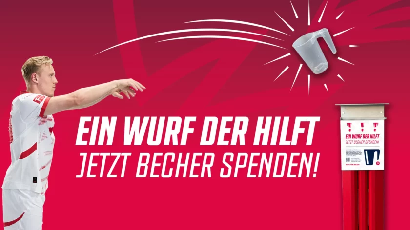 Ein Fußballspieler in weißem Trikot wirft einen Plastikbecher in einen Spendencontainer. Der Hintergrund ist rot mit weißen Schriftzügen, die "Ein Wurf der hilft. Jetzt Becher spenden!" und "Ein Wurf der hilft. Jetzt Becher spenden!" auf dem Container lauten.