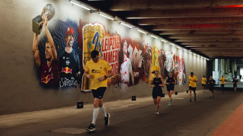 Läufer in einem Tunnel mit Wandgemälde des RB Leipzig.