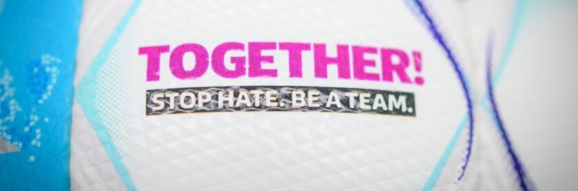 Ein Fußball mit den Aufschriften "TOGETHER!" in pink und "STOP HATE. BE A TEAM." in silber.