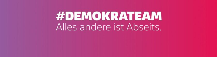 Bild mit pinkem Hintergrund und weißer Schrift. Der Text lautet '#DEMOKRATEAM Alles andere ist Abseits.' Der Fokus liegt auf der Bedeutung von Demokratie und Teamwork.