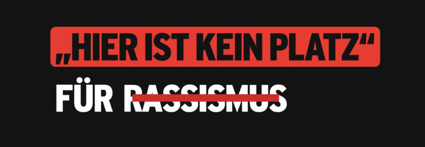 Hier ist kein Platz für Rassismus" - ein klares Statement gegen Rassismus auf schwarzem Hintergrund.