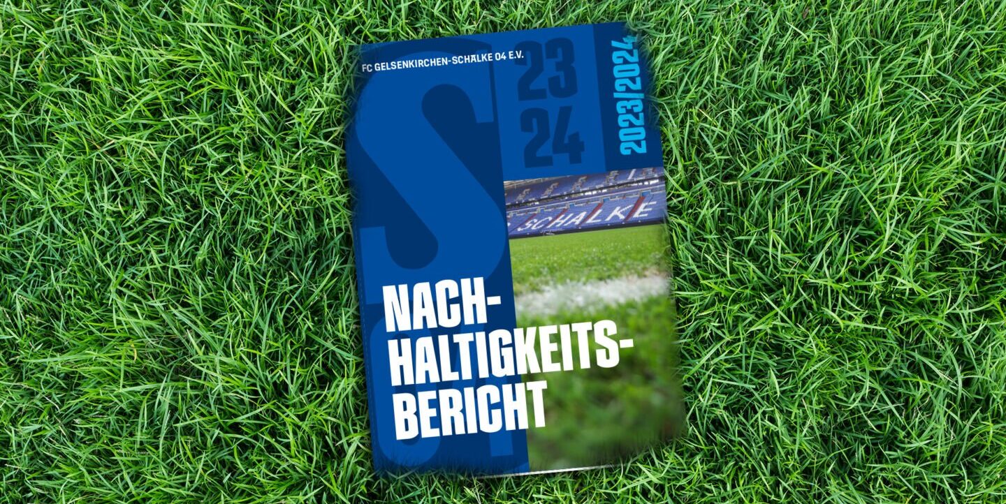 Ein Nachhaltigkeitsbericht des FC Gelsenkirchen-Schalke 04 e.V. liegt auf grünem Rasen. Der Bericht trägt den Titel "Nachhaltigkeitsbericht" und zeigt im Hintergrund eine Stadionansicht.