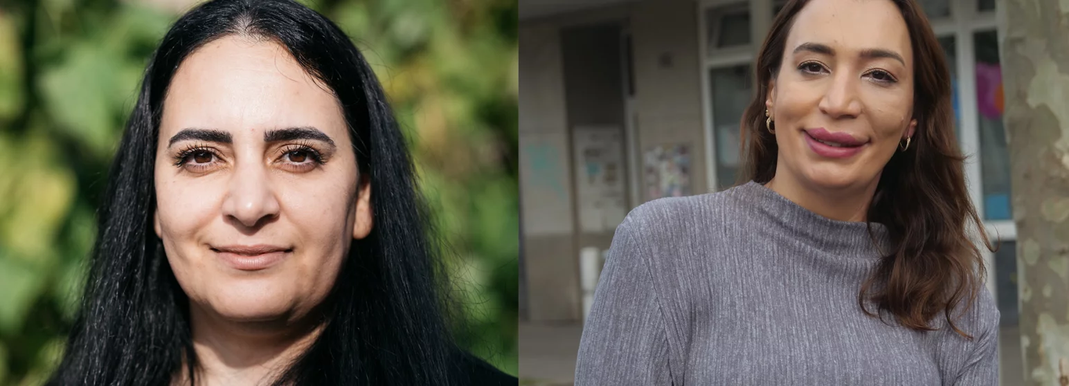 Zwei lächelnde Frauen vor einem grünen Hintergrund und einem Gebäude. Beide Frauen haben lange, dunkle Haare und tragen graue Oberteile. Die linke Frau schaut direkt in die Kamera, während die rechte Frau leicht zur Seite schaut.