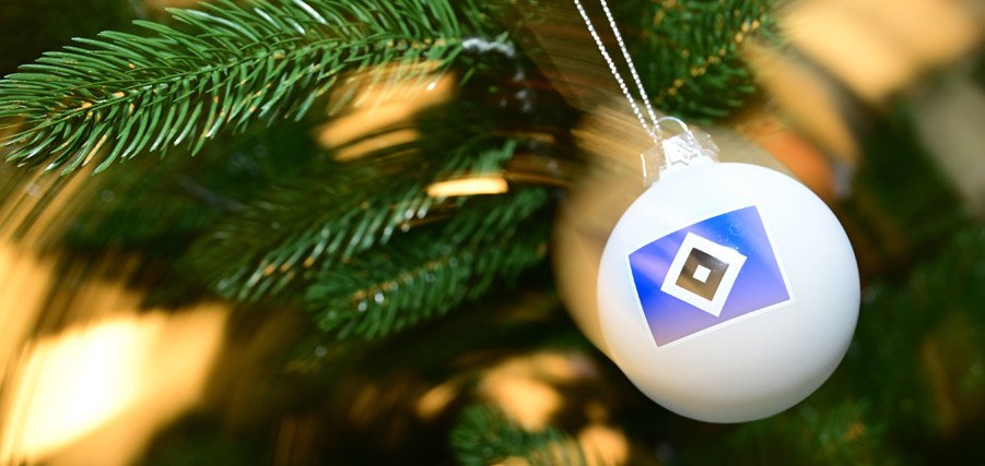 Weihnachtsbaumschmuck mit dem Logo der Sparda-Bank Hamburg hängt an einem grünen Tannenzweig.