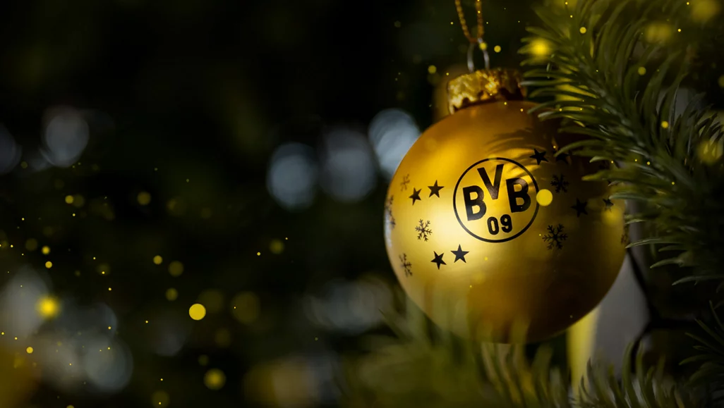 Goldene Weihnachtskugel mit dem BVB-Logo und Sternen am Weihnachtsbaum.