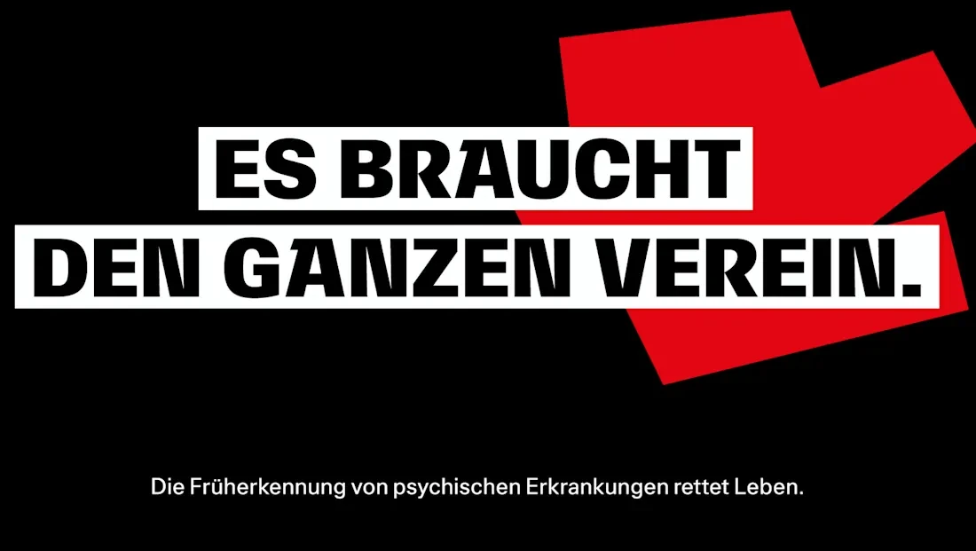 Schwarzes Bild mit rotem und weißem Text, der den Satz 'ES BRAUCHT DEN GANZEN VEREIN.' bildet. Darunter steht der Satz 'Die Früherkennung von psychischen Erkrankungen rettet Leben.' als Untertitel.
