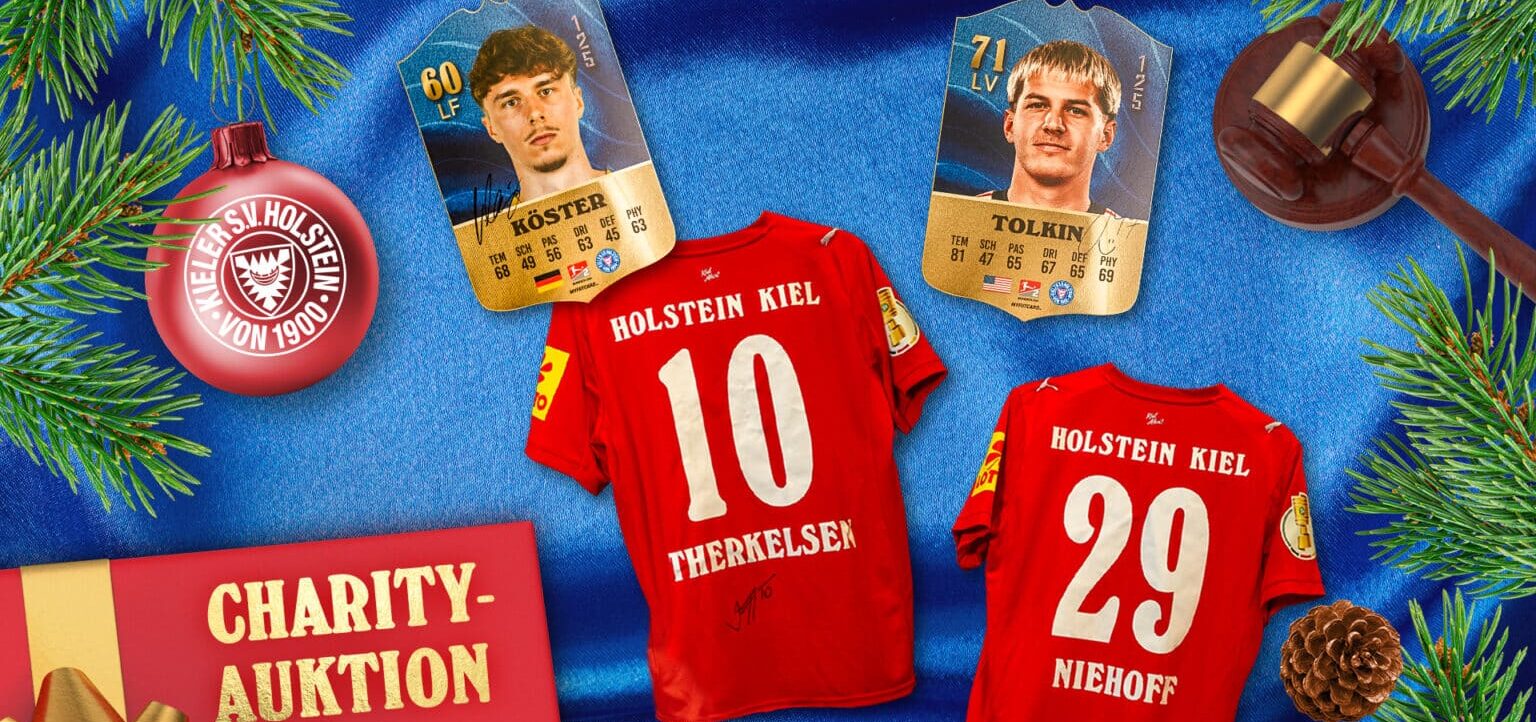 Zwei signierte Trikots des Vereins Holstein Kiel, die für eine Charity-Auktion angeboten werden. Die Trikots tragen die Nummern 10 und 29 und die Namen Therkelsen und Niehoff. Im Hintergrund sind zwei Sammelkarten von Spielern des Vereins sowie eine Weihnachtsdekoration mit Tannenzweigen, einer roten Weihnachtskugel mit dem Vereinslogo und einem kleinen goldenen Hammer zu sehen.