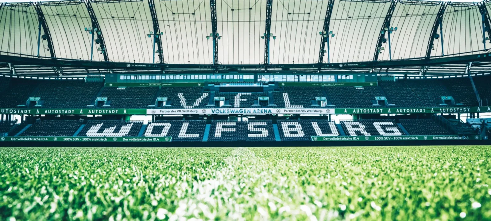 Ein Blick auf das Spielfeld der Volkswagen Arena des VFL Wolfsburg mit der Überschrift "WOLFSBURG" auf den Sitzplätzen.